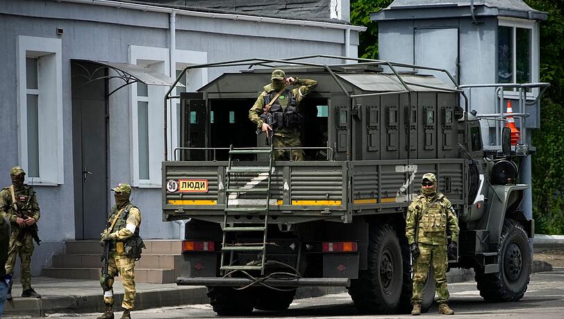 Russische Soldaten bewachen im Mai 2022 ein Gelände in Cherson, das von ausländischen Journalisten besucht wird. (Archivbild)