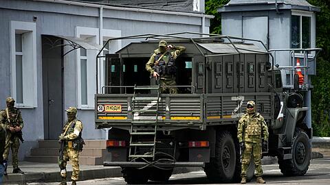 Russische Soldaten bewachen ein Gelände in Cherson, das von ausländischen Journalisten besucht wird.