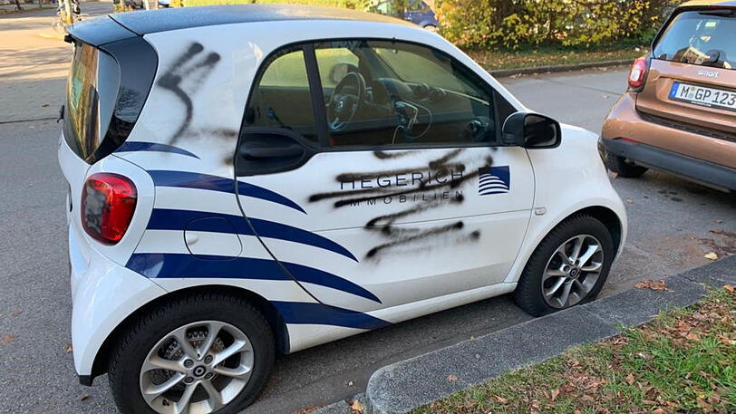 Der besprühte Smart steht mit platten Reifen am Hansapark in Sendling.