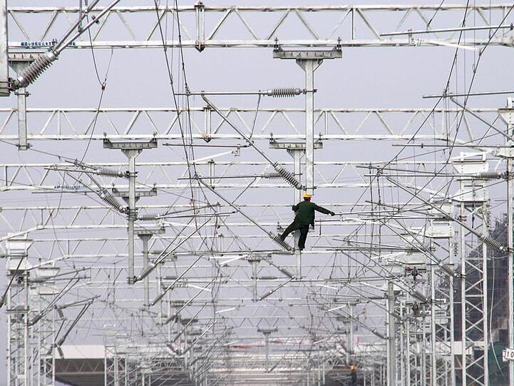 Ein Arbeiter montiert Elektroleitungen an der Baustelle einer Eisenbahn im Südosten Chinas.