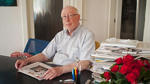Der Prager Publizist Petr Brod sitzt mit einer Zeitung an einem Tisch. Brod arbeitete von 1987 bis 1993 für Radio Freies Europa (RFE).