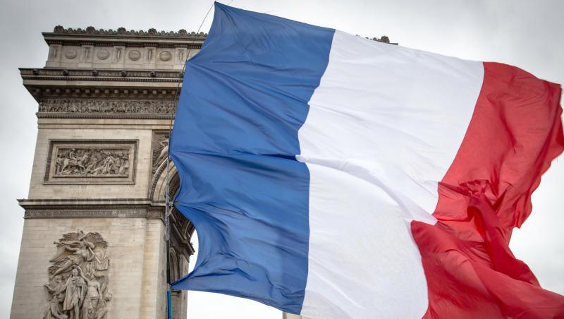 Teilnehmer einer Demonstration der "Gelbwesten" gehen mit einer französischen Nationalflagge am Arc de Triomphe in Paris entlang. Teilnehmer einer Demonstration der "Gelbwesten" gehen mit einer französischen Nationalflagge am Arc de Triomphe in Paris entlang.