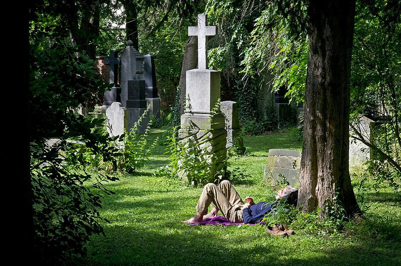 Gruselig: Bräune tanken neben einem Grabkreuz
