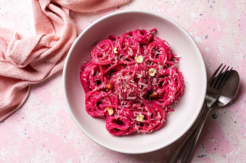 Legen Sie eine halbierte kleine Gem&uuml;sezwiebel, zwei Knoblauchzehen, zwei EL Oliven&ouml;l und vier Thymianzweige auf Alufolie. Verschlie&szlig;en Sie beide P&auml;ckchen und backen Sie sie 30 Minuten im Ofen. Kurz vor Ende der Garzeit kochen Sie die Pasta nach Packungsanleitung. Sch&auml;len Sie dann die Rote Bete und geben Sie sie mit Knoblauch, Zwiebel, 50 Gramm Ziegenweichk&auml;se, vier EL Nudelwasser und einem Spritzer Zitronensaft in einen Mixer. Dann alles zu einer Creme p&uuml;rieren.