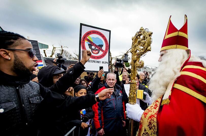 Nur unter Polizeischutz konnte der Nikolaus unbeschadet durch die Menschenmasse wandern. Demonstranten plädieren für die Abschaffung des Schwarzen Peter.