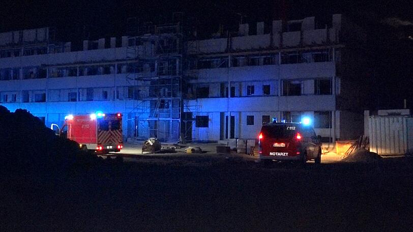 Kleve: Rettungsfahrzeuge stehen vor einem Haus auf einer Baustelle. Bei einem Sturz von einem Baukran ist ein junger Mann tödlich verletzt worden.