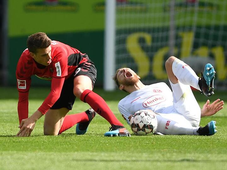Freiburgs Janik Haberer (l) foult Adam Bodzek und sieht die gelb-rote Karte.