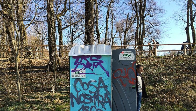 Neben der Wittelsbacher Brücke laufen Fußgänger, Jogger und fahren Radler. Unten verrichtet jemand seine Notdurft. Neben der Wittelsbacher Brücke laufen Fußgänger, Jogger und fahren Radler. Unten verrichtet jemand seine Notdurft.