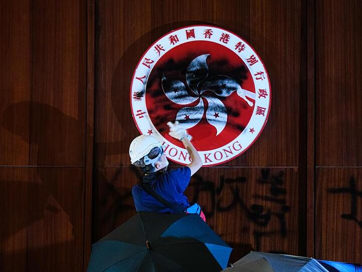 Im Hongkonger Parlament, dem Gebäude des Legislativrats, schwärzt ein Demonstrant das Emblem der Stadt.