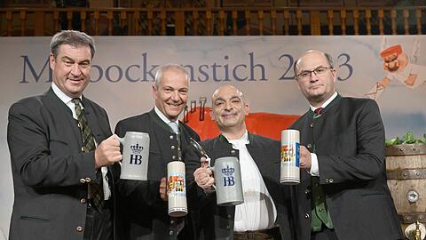 Der Bayerische Ministerpräsident Markus Söder (CSU), (l-r) Hofbräu-Brauereidirektor Michael Möller, der Kabarettist Django Asül und Albert Füracker, Staatsminister der Finanzen und für Heimat stehen beim Maibock-Anstich im Hofbräuhaus auf der Bühne.