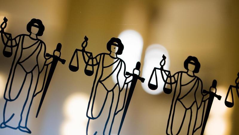 Justitia-Abbildungen sind an einer Scheibe zu sehen.