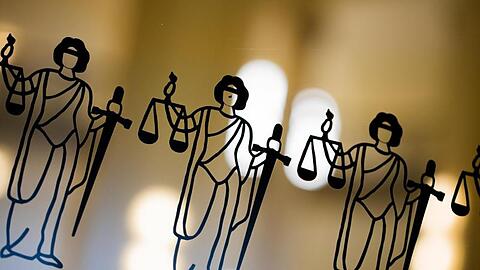 Justitia-Abbildungen sind an einer Scheibe zu sehen.