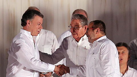 Präsident Juan Manuel Santos (L) und der Kommandeur der Farc, Rodrigo Londono, nach der Unterzeichnung des Abkommens. Foto: Mauricio Duenas Castaneda