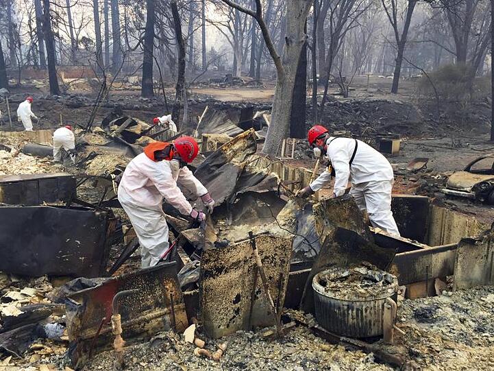 Freiwillige Rettungskräfte suchen in den Trümmern von Häusern, die dem "Camp"-Feuer zum Opfer gefallen sind, nach menschlichen Überresten.