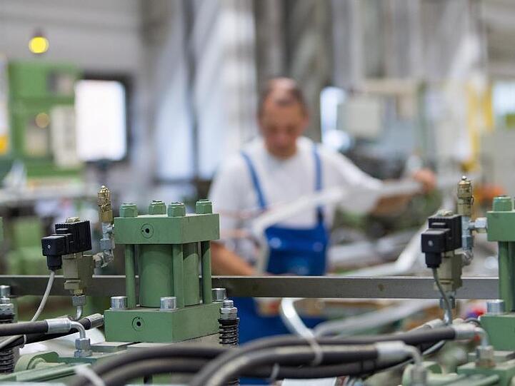 Ein Arbeiter bedient eine Maschine. Foto: Monika Skolimowska/Archiv