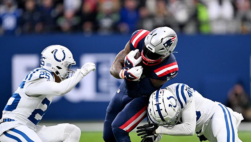 New Englands Ezekiel Elliott (M) wird von zwei Colts-Verteidigern gestoppt.