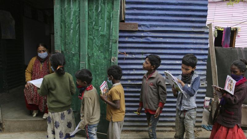 Eine Lehrerin in einem Armutsviertel am Rande der indischen Stadt Jammu korrigiert Schulhefte.