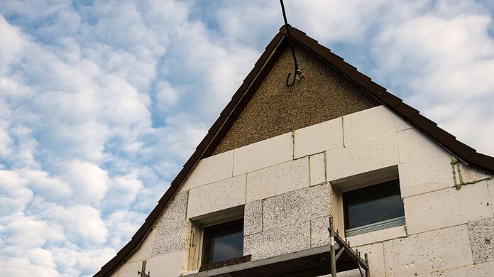 Ein Haus aus den 1930er-Jahren wird in Berlin mit Styroporplatten auf der Außenwand gedämmt.