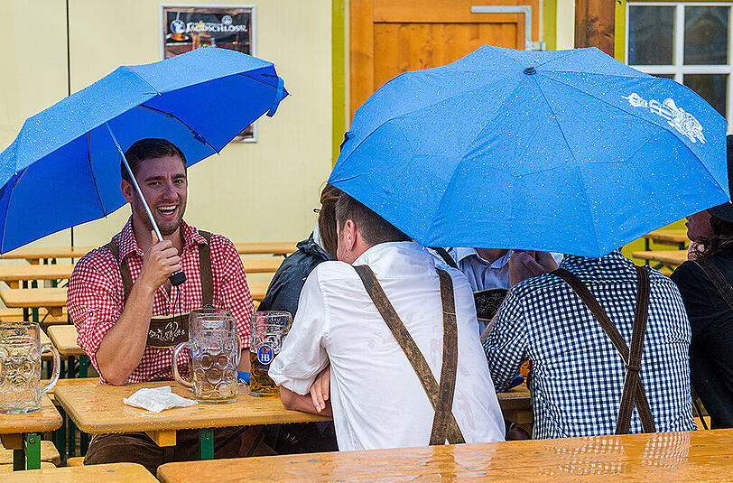 Wiesn-Besucher sollten zumindest am ersten Wochenende einen Regenschirm mitnehmen.