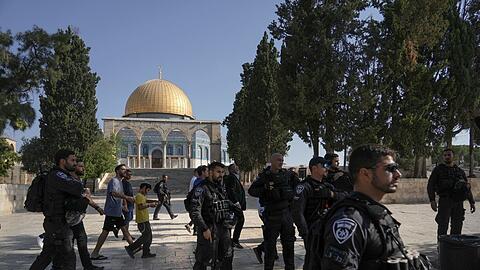 Israelische Polizisten eskortieren eine Gruppe jüdischer Männer zum Tempelberg in der Altstadt von Jerusalem - im Hintergrund die Al-Aqsa-Moschee.