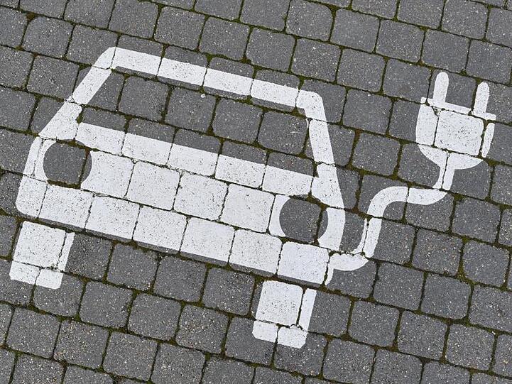 Ein Piktogramm zeigt einen Elektrofahrzeug-Parkplatz. Die Nachfrage nach Elektroautos und Hybriden in Deutschland ist deutlich gestiegen.