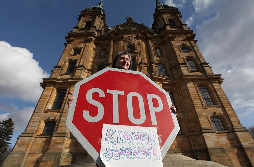 Die katholische Kirche hatte in den letzten Jahren mit vielen Krisen zu kämpfen. Hier ein Demonstrant mit einem "Stopp Kinderschänder"-Schild vor der Freisinger Bischofskonferenz.