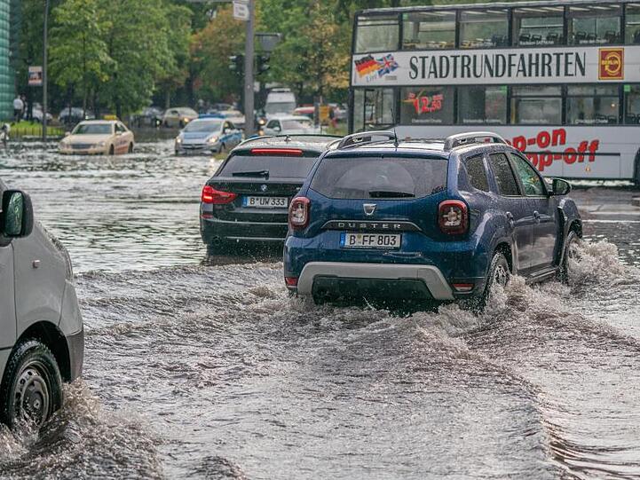 Autos fahren über die überflutete Tiergartenstraße in Berlin-Mitte.
