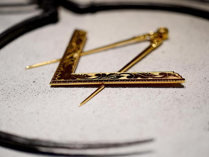 Ein Zirkel und ein Winkel, die Symbole der Freimaurer, liegen im Freimaurermuseum. Foto: David-Wolfgang Ebener/dpa/Archivbild