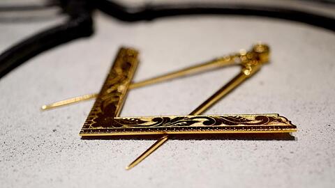 Ein Zirkel und ein Winkel, die Symbole der Freimaurer, liegen im Freimaurermuseum. Foto: David-Wolfgang Ebener/dpa/Archivbild