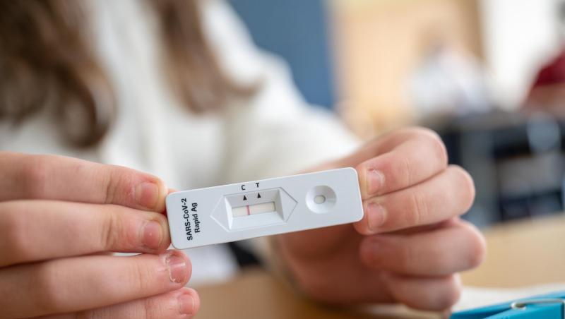 Ein Schülerin zeigt in einer Klasse ihren negativen Corona-Schnelltest.