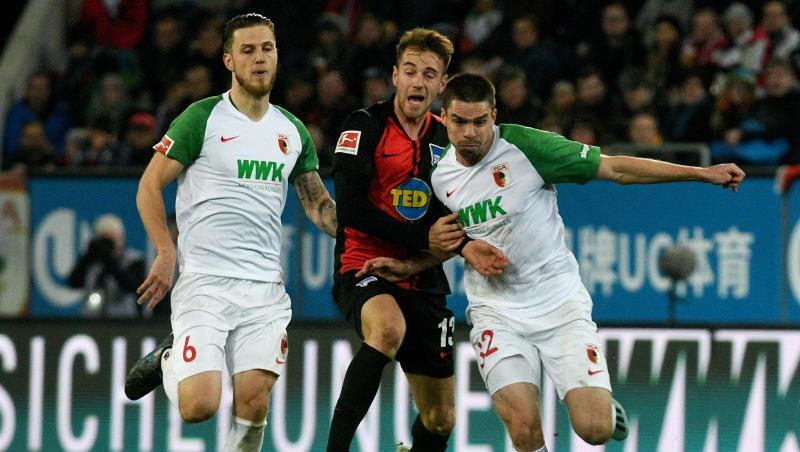 Raphael Framberger (r) und Jeffrey Gouweleeuw kämpfen mit Herthas Lukas Klünter um den Ball. Foto: Stefan Puchner/dpa/Archivbild Raphael Framberger (r) und Jeffrey Gouweleeuw kämpfen mit Herthas Lukas Klünter um den Ball. Foto: Stefan Puchner/dpa/Archivbild