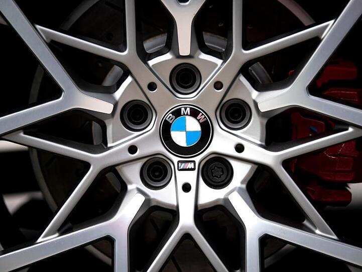 Das Logo des Münchner Autobauers BMW ist auf den Felgen eines Autos zu sehen. Foto: Sina Schuldt/Archivbild