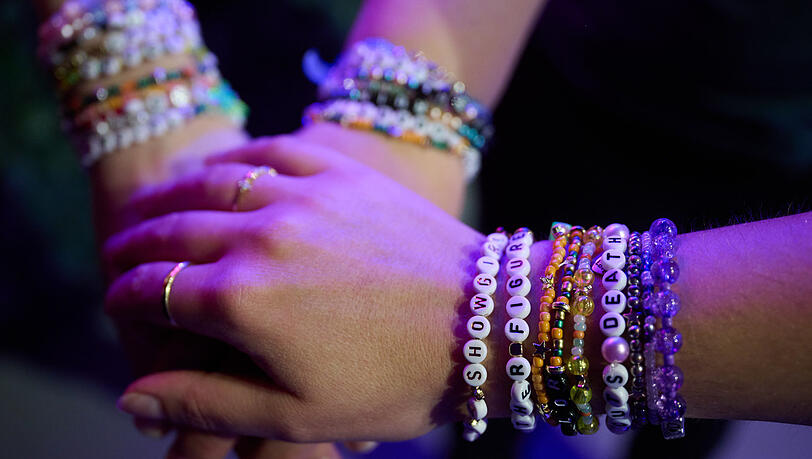 Taylor Swift Fans zeigen ihre Armbänder, auf denen Teile von Songtexten zu lesen sind. Taylor Swift Fans zeigen ihre Armbänder, auf denen Teile von Songtexten zu lesen sind.