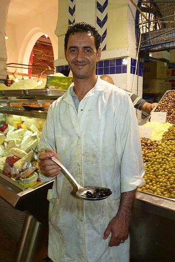 Olivenverkäufer in der Markthalle von Tunis