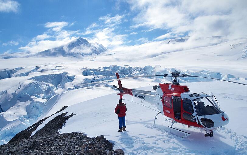 Was für eine Aussicht: ein Forscher der Bundesanstalt für Geowissenschaften und Rohstoffe steht neben einem Hubschrauber im Gebiet Nordviktorialand in der Antarktis. Forscher versuchen auf einer Expedition in der Antarktis herauszufinden, wie der Kontinent entstanden ist.