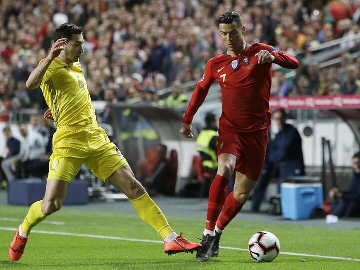 Portugals Superstar Cristiano Ronaldo (r) wird vom Ukrainer Taras Stepanenko unter Druck gesetzt.