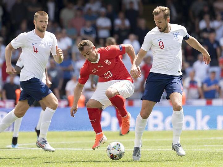 Xherdan Shaqiri (M) aus der Schweiz im Zweikampf mit Harry Kane.