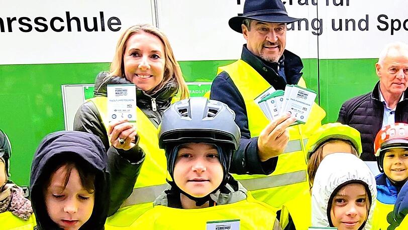 Anna Stolz und Markus Söder verteilen Radlführerscheine.