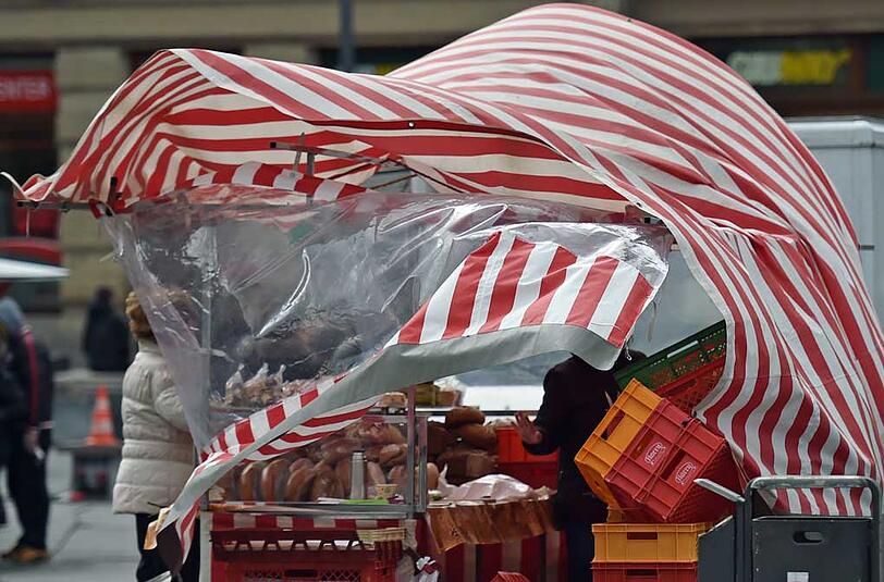 Eine Windböe hat einen Bäckerstand auf dem Markt in Halle (Saale) (Sachsen-Anhalt) erfasst und bläht die Zeltwände auf.