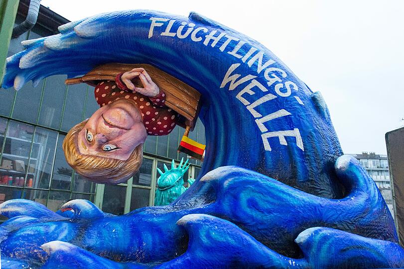 Ein Karnevalswagen zeigt in Düsseldorf das Motiv "Flüchtlingswelle" mit der Figur der Bundeskanzlerin Angela Merkel. Der Düsseldorfer Rosenmontagzug wurde wegen Sturms abgesagt.