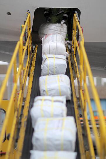 Hilfsgüter sind auf einem Rollband auf dem Weg ins Flugzeug. Von der ganzen Welt kommen Hilfsgüter - auch aus Deutschland.