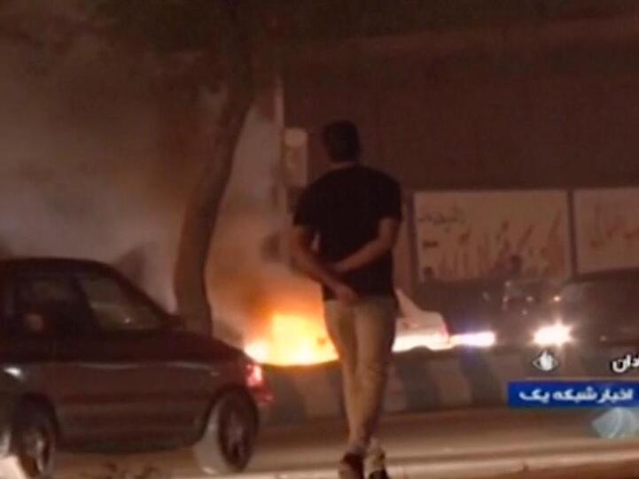 Das Videostandbild, das die staatliche Rundfunkgesellschaft der Islamischen Republik Iran zur Verfügung gestellt hat, geht ein Mann an einem Feuer vorbei, das von Demonstranten in Abadan gelegt wurde.