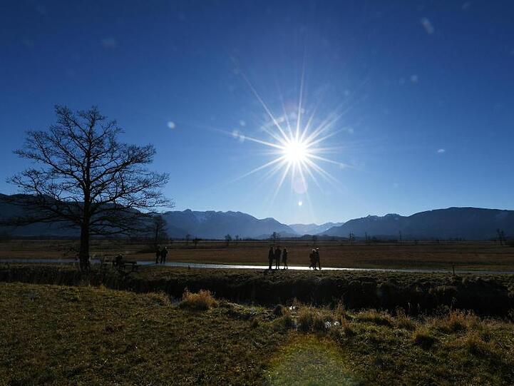 Spaziergänger genießen die Sonne. Foto: Angelika Warmuth/dpa/Archivbild