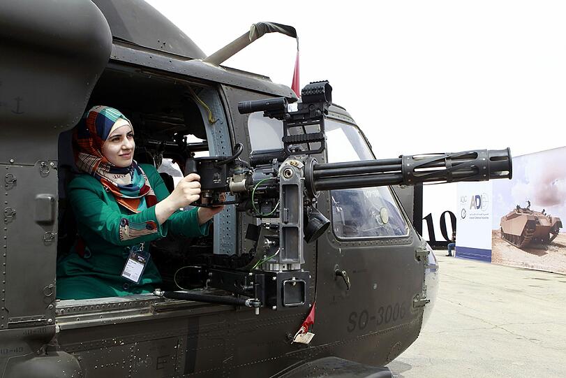 Eine Frau steht in der jordanischen Hauptstadt Amman an einem Hubschrauber-Geschütz. Dort ist derzeit die Special Operations Forces Exhibition & Conference
