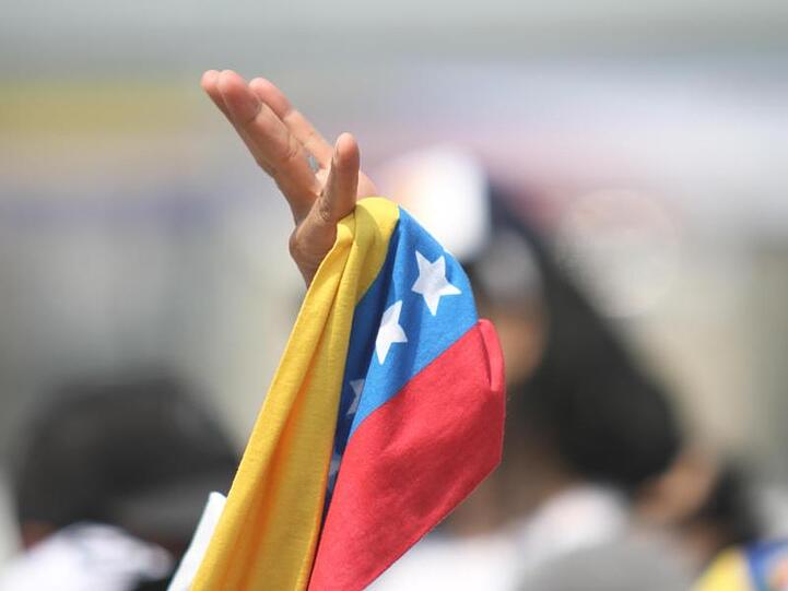 Ein Zuschauer schwenkt bei dem Benefizkonzert "Venezuela Aid Live" auf der kolumbianischen Seite der Grenzbrücke Tiendita eine Fahne.