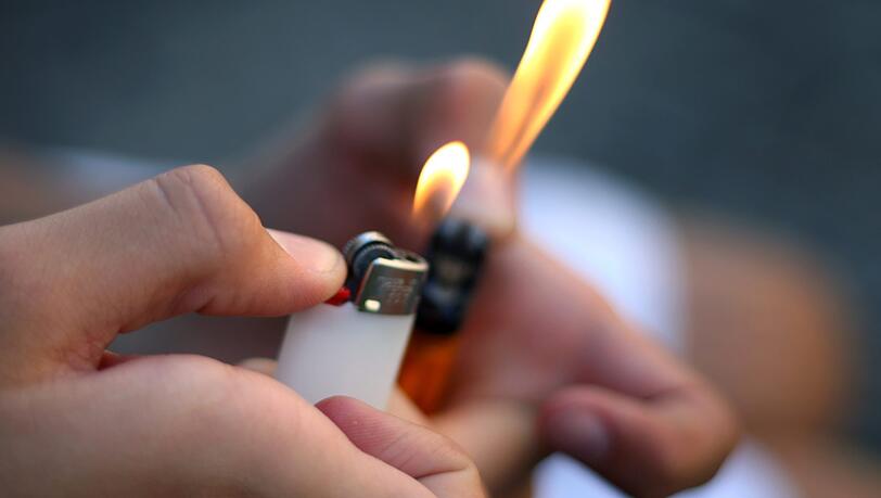 Ein Junge spielt mit zwei Feuerzeugen. (Symbolbild) Ein Junge spielt mit zwei Feuerzeugen. (Symbolbild)