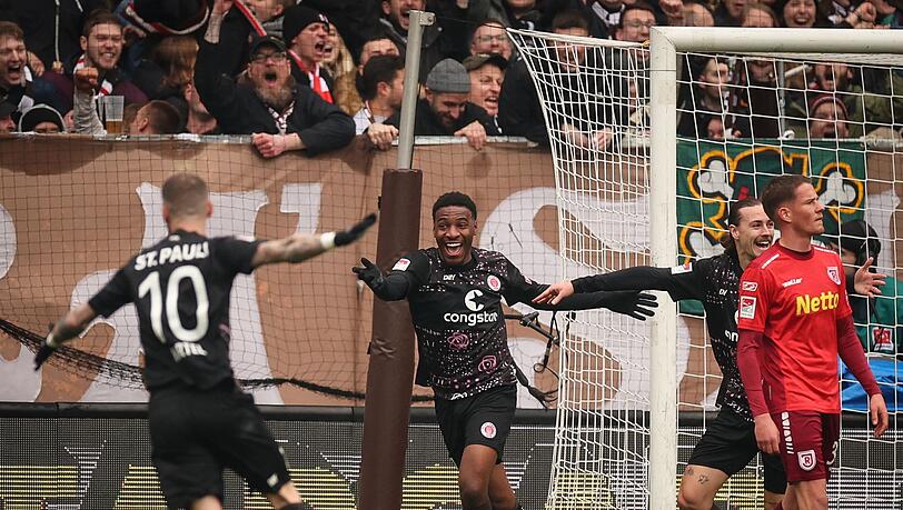 Sankt Paulis Oladapo Afolayan (2.v.l) feiert nach dem Tor zum 1:0 gegen Regensburg. Das Tor wurde dann als Eigentor von Owusu gewertet.