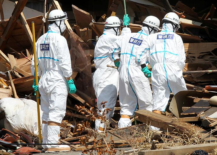 Makabre Aufgabe: Japanische Soldaten suchen in den Trümmern nach Leichen.