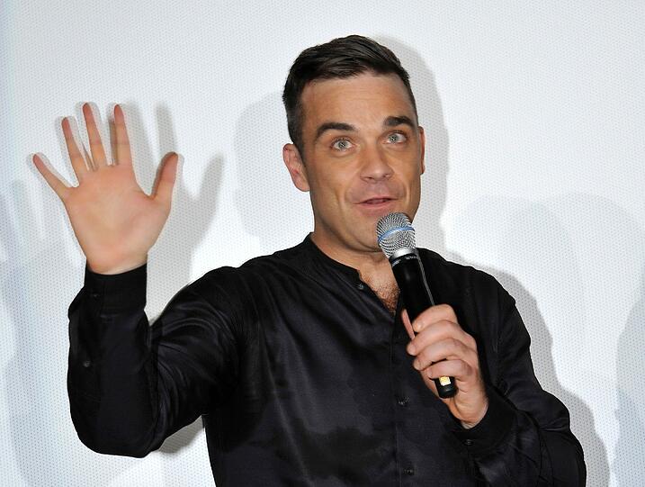 Weltstar im Fan-Gewusel: Robbie Williams verteilte Autogramme vor dem Mathäser-Kino.