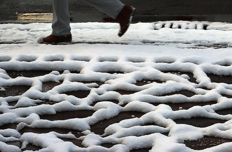Ein grafisches Muster bildet der liegengebliebene Schnee zwischen den Steinplatten einer Einfahrt am 22.11.2015 in Kaufbeuren (Bayern).